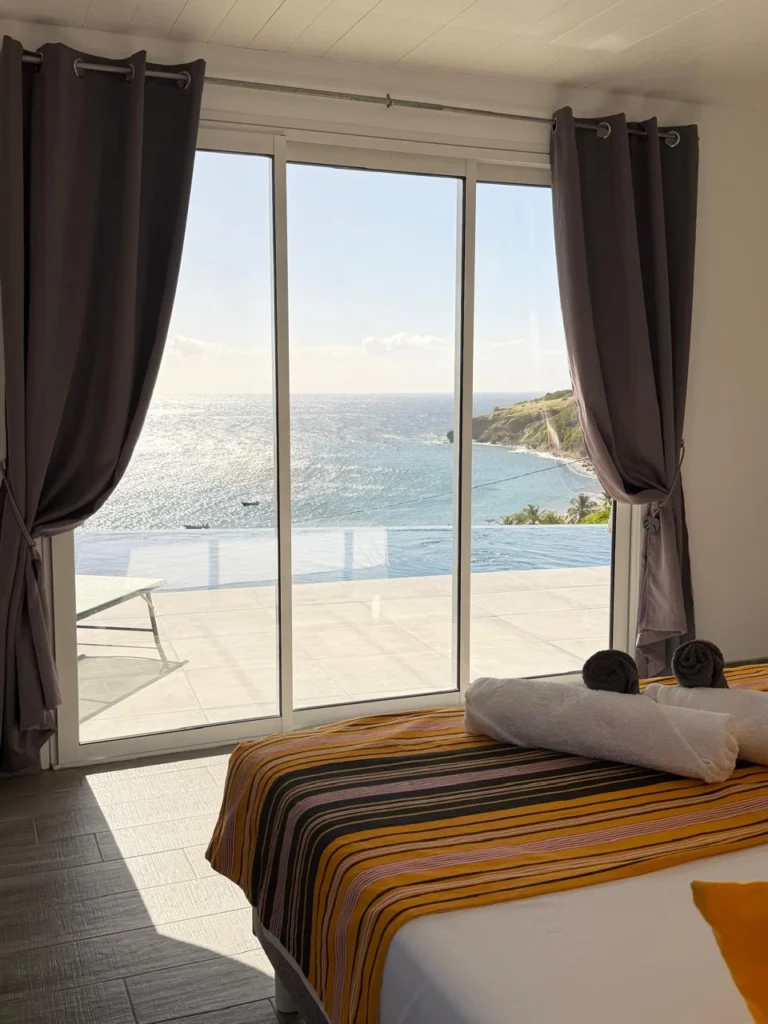 Chambre parentale vue mer en Martinique avec accès direct piscine et salle de bain PMR