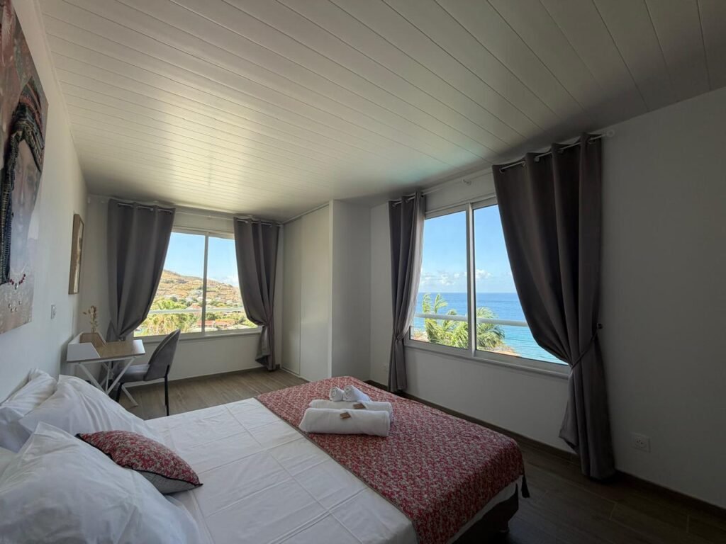 Suite parentale climatisée avec vue panoramique sur la mer des Caraïbes à la Villa Marine Blue, aux Anses-d’Arlet en Martinique.